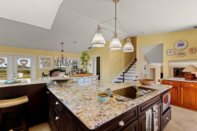 kitchen featuring vaulted ceiling, black electric stovetop, light stone countertops, and french doors