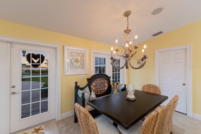 dining space featuring a notable chandelier, visible vents, baseboards, and vaulted ceiling