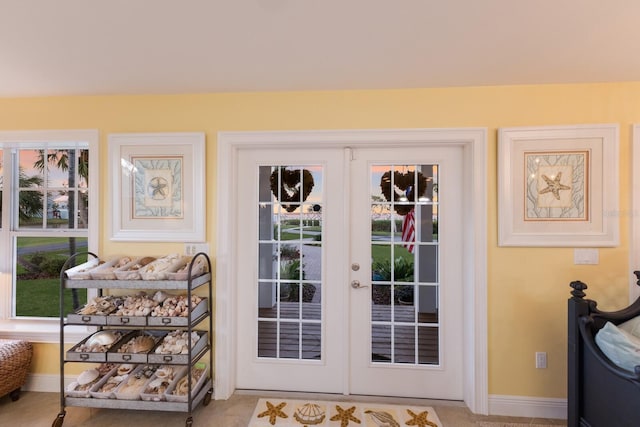 doorway to outside with french doors and baseboards