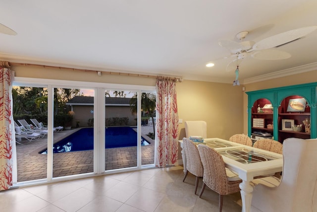 dining room with tile patterned flooring, crown molding, and ceiling fan