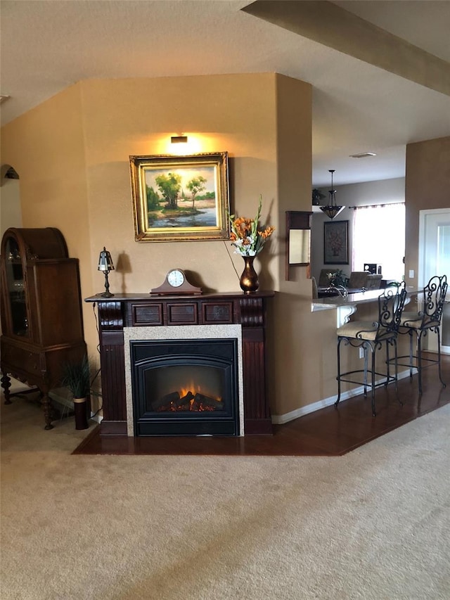 room details featuring a glass covered fireplace, baseboards, and carpet floors