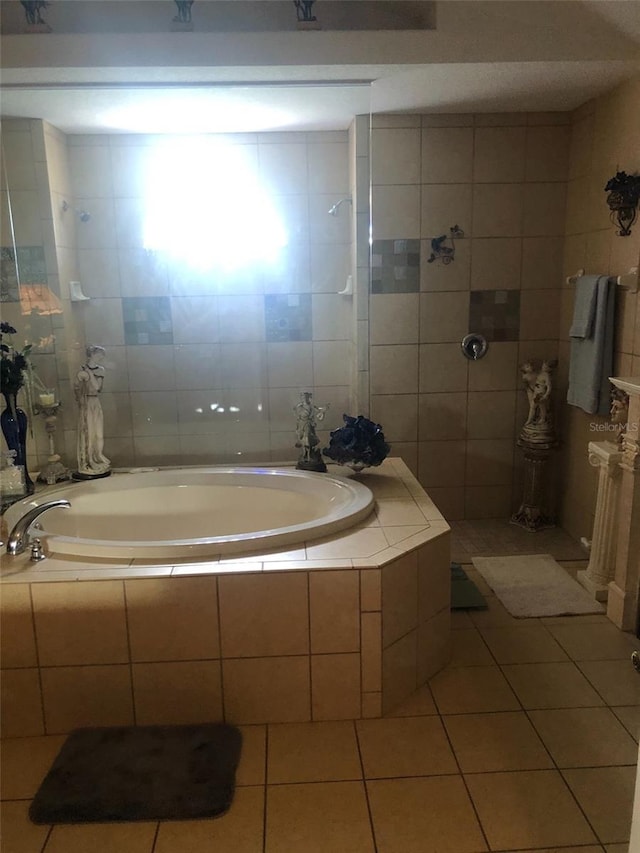 bathroom with tiled tub, tile walls, a tile shower, and tile patterned flooring