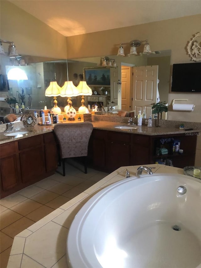 bathroom with vanity, tile patterned floors, and a bath