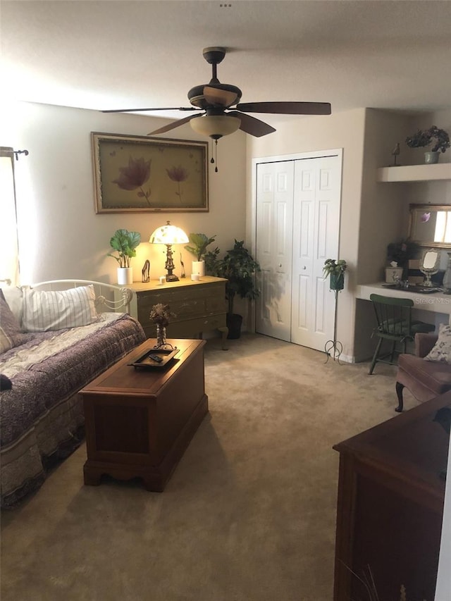 carpeted living area featuring a ceiling fan