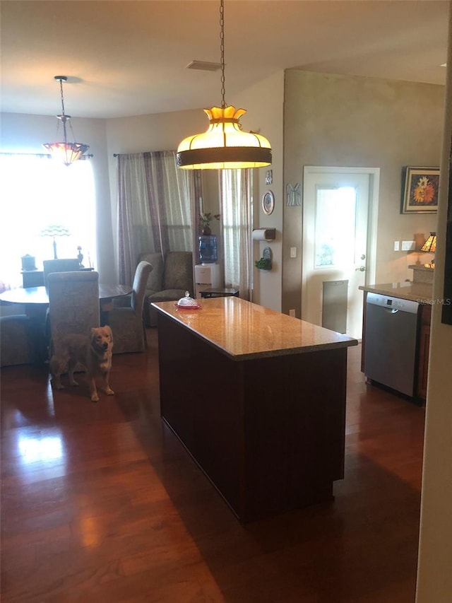 kitchen featuring decorative light fixtures, light stone counters, dishwasher, and dark wood finished floors