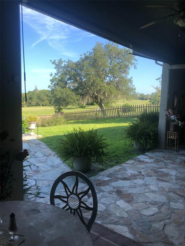 view of patio / terrace featuring a rural view and fence