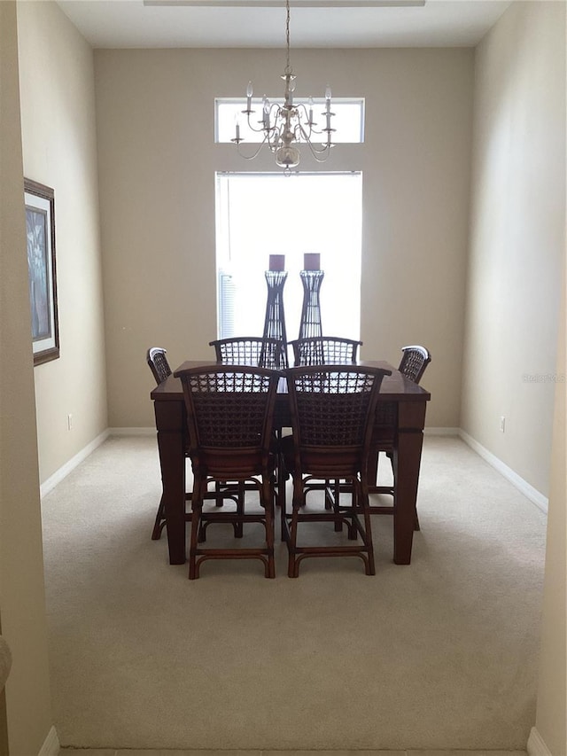 dining space with baseboards, carpet flooring, and a notable chandelier