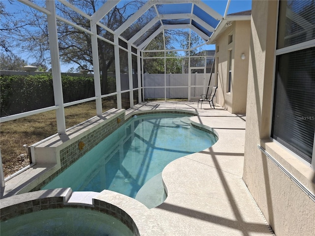 view of swimming pool with glass enclosure, a patio area, a fenced backyard, and a pool with connected hot tub