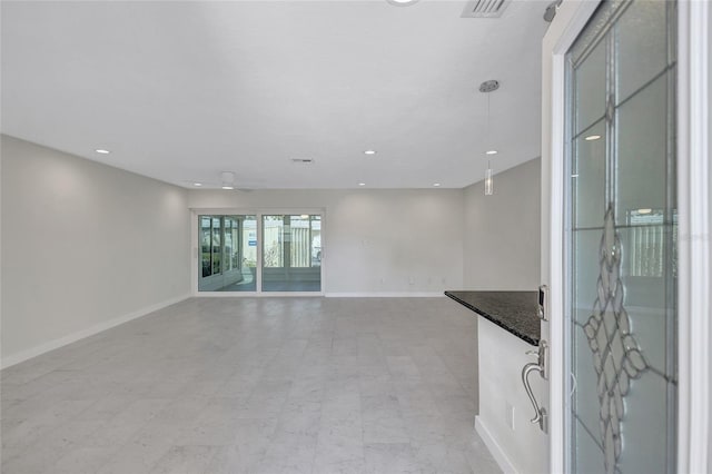 unfurnished living room with visible vents, recessed lighting, and baseboards