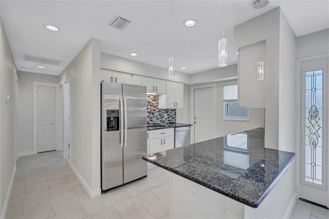 kitchen with decorative backsplash, recessed lighting, a peninsula, stainless steel appliances, and white cabinetry