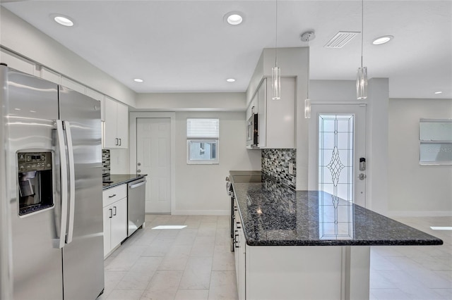 kitchen with tasteful backsplash, recessed lighting, appliances with stainless steel finishes, a peninsula, and white cabinets