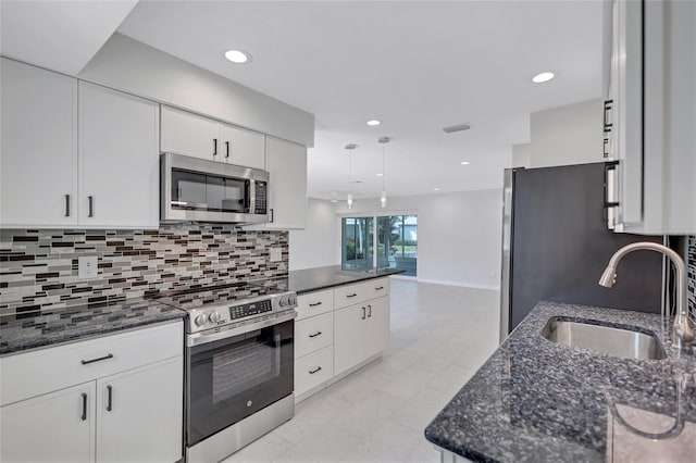 kitchen featuring white cabinets, tasteful backsplash, appliances with stainless steel finishes, and a sink