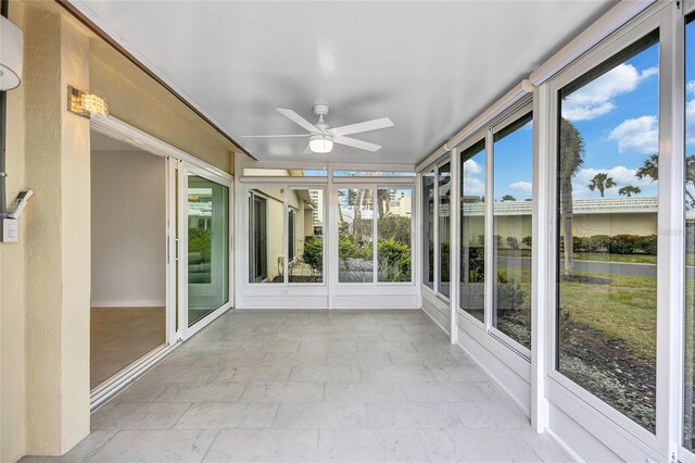 unfurnished sunroom featuring ceiling fan