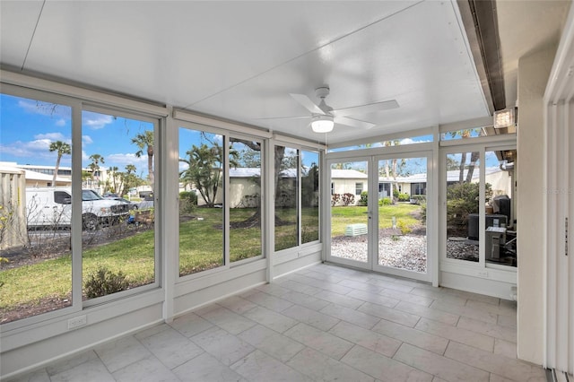 unfurnished sunroom featuring a residential view and ceiling fan