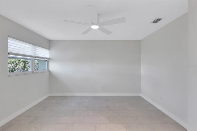 unfurnished room with visible vents, a ceiling fan, and baseboards