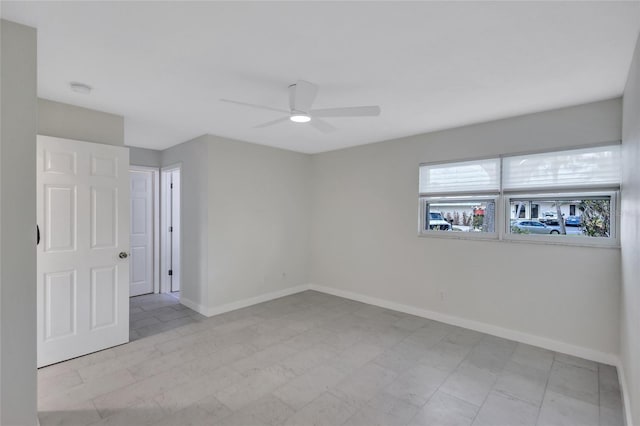 unfurnished room featuring baseboards and a ceiling fan