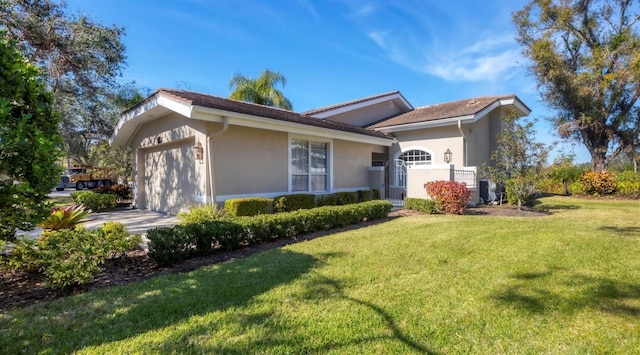 view of side of property with a garage, stucco siding, driveway, and a yard