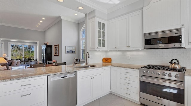 kitchen with light tile patterned floors, appliances with stainless steel finishes, light stone countertops, crown molding, and a sink