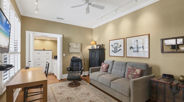 living room featuring crown molding, visible vents, a ceiling fan, wood finished floors, and baseboards