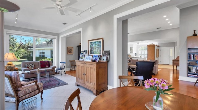 interior space featuring visible vents, ornamental molding, a ceiling fan, and baseboards