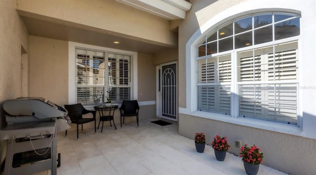 entrance to property with stucco siding and a patio