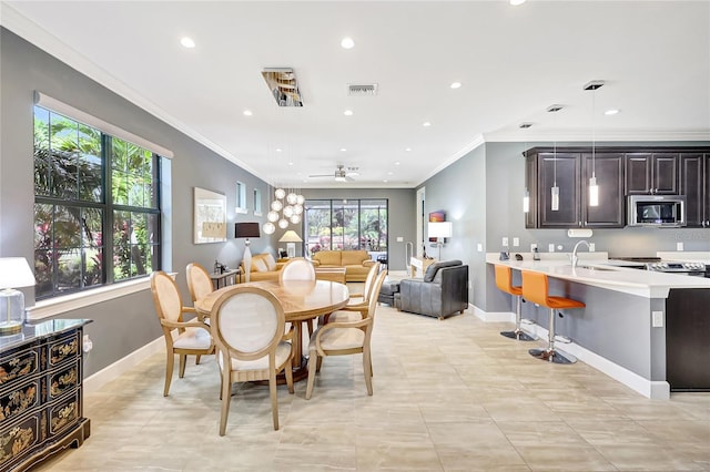 dining room with visible vents, baseboards, crown molding, and ceiling fan