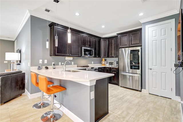 kitchen featuring stainless steel appliances, a breakfast bar, a sink, and dark brown cabinetry