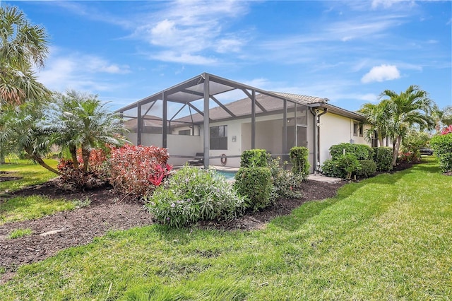 back of property featuring a lanai and a yard