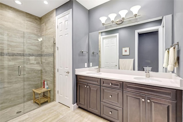 full bath with double vanity, a stall shower, and a sink