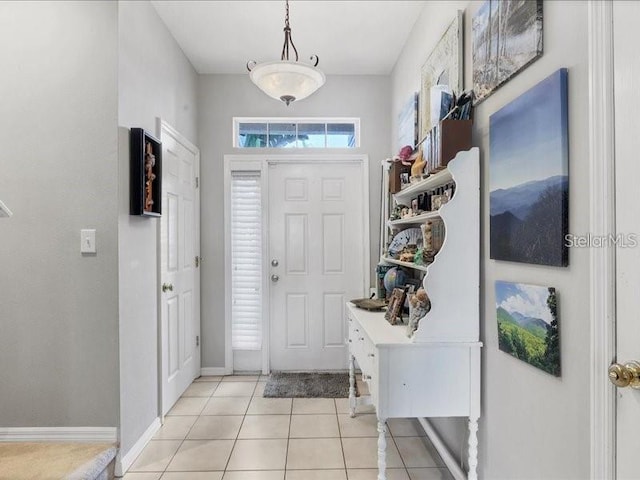 foyer entrance with light tile patterned floors and baseboards