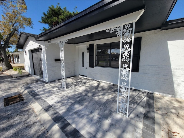 deck featuring an attached garage and a porch