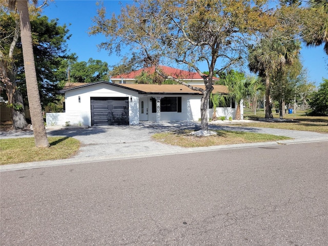 view of front of house featuring driveway, an attached garage, and stucco siding