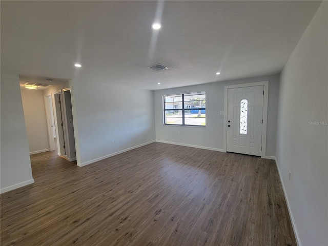 foyer entrance with baseboards, visible vents, dark wood finished floors, and recessed lighting