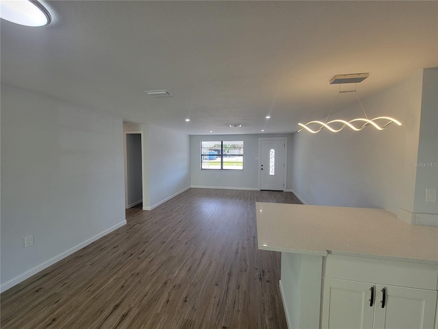 interior space featuring dark wood-type flooring, recessed lighting, and baseboards