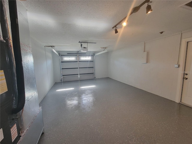 garage with concrete block wall and a garage door opener