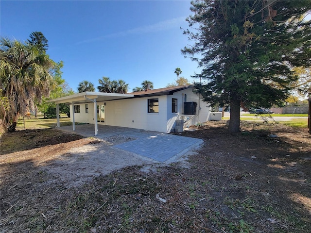 back of property featuring a patio, an attached carport, fence, and driveway