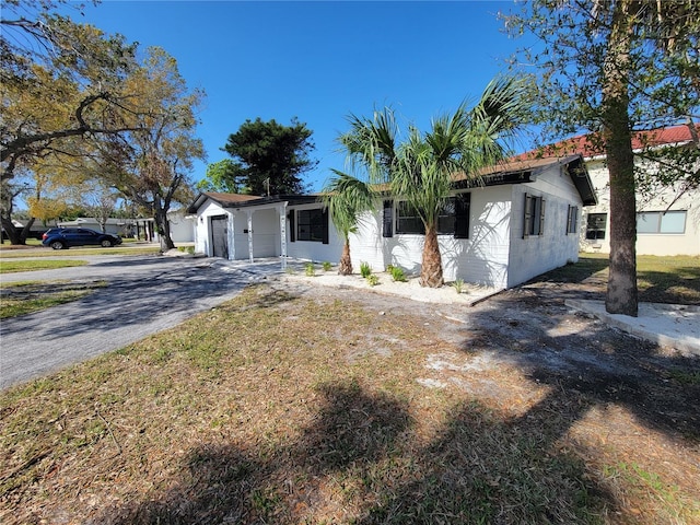 ranch-style house featuring an attached garage, driveway, and concrete block siding