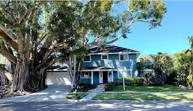 view of front facade with driveway, covered porch, an attached garage, and a front lawn