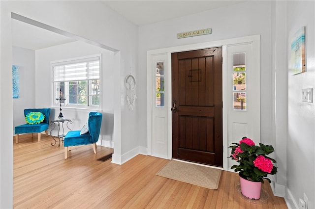 entryway featuring baseboards, visible vents, and wood finished floors