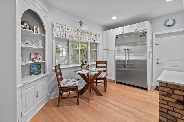 dining space featuring light wood-type flooring, built in features, and recessed lighting