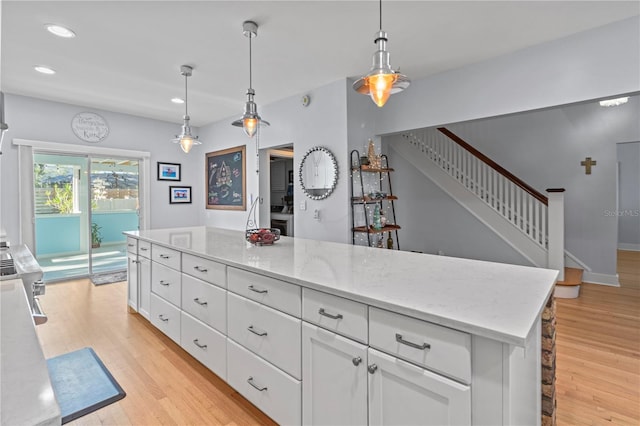 kitchen featuring light stone counters, decorative light fixtures, recessed lighting, light wood-style flooring, and white cabinets