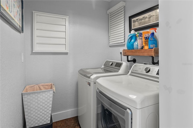 laundry area with a textured wall, laundry area, washing machine and dryer, and baseboards