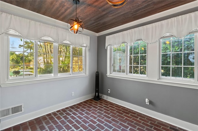 unfurnished room with wood ceiling, brick floor, visible vents, and baseboards