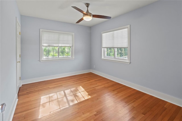 unfurnished room with plenty of natural light, light wood-style flooring, and baseboards