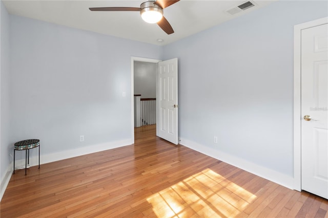 unfurnished room featuring a ceiling fan, baseboards, visible vents, and light wood finished floors