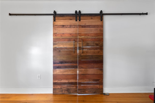 details with a barn door, baseboards, and wood finished floors