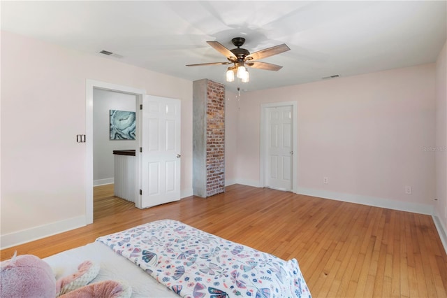 bedroom featuring a ceiling fan, baseboards, visible vents, and light wood finished floors