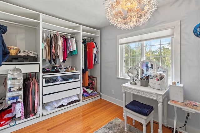 spacious closet featuring a chandelier and wood finished floors