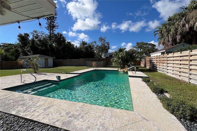 view of pool with a patio, a fenced backyard, an outdoor structure, a lawn, and a fenced in pool