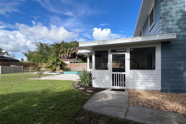 doorway to property featuring fence, a fenced in pool, and a yard